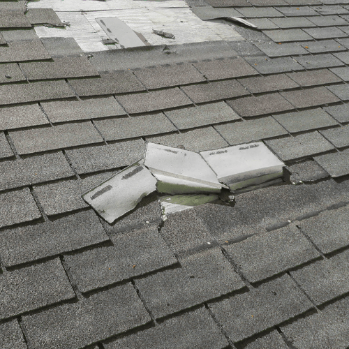 missing and damaged shingles on a roof needing replacement.