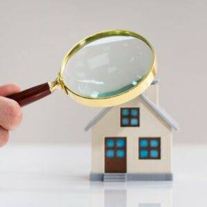 roof inspection, magnifying glass over a small model house